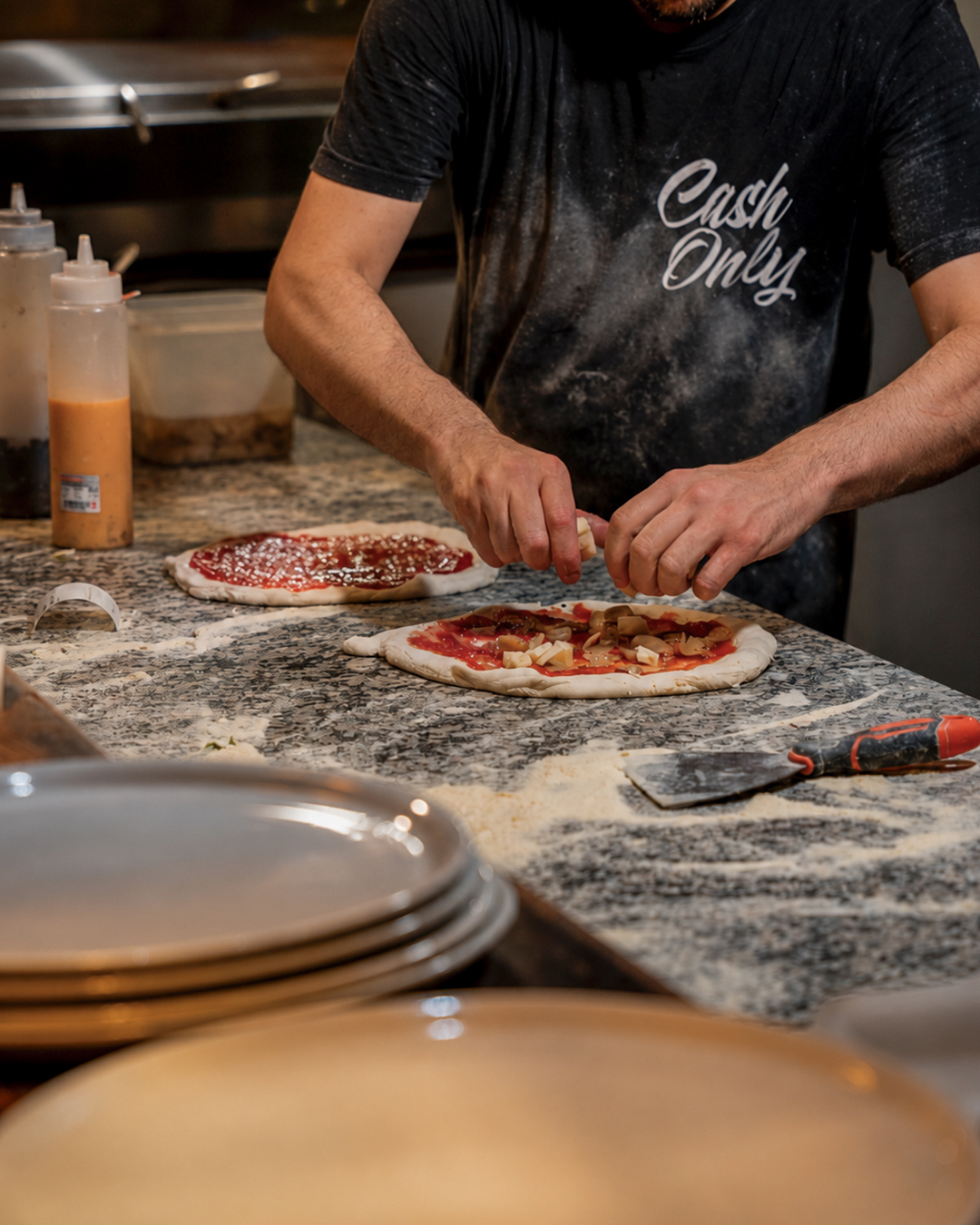 Pizzero preparando una pizza a mano